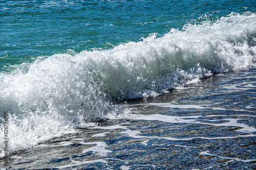 Sea waves on the beach on a sunny day.