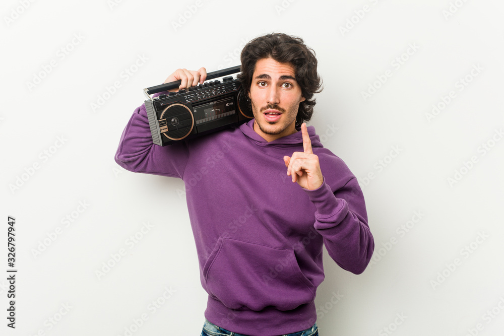 Young urban man holding a guetto blaster having an idea, inspiration concept. Young urban man holding a guetto blaster having an idea, inspiration concept.