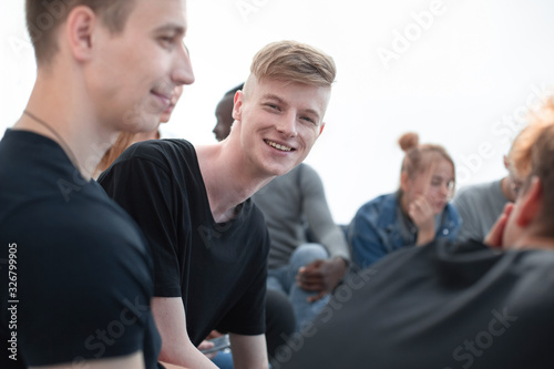 Fototapeta Naklejka Na Ścianę i Meble -  smiling guy sitting in a circle at a group meeting