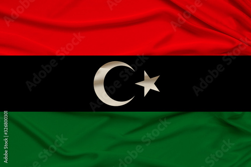 beautiful photo of the national flag of Libya on delicate shiny silk with soft draperies, the concept of state power, country life, horizontal, close-up, copy space