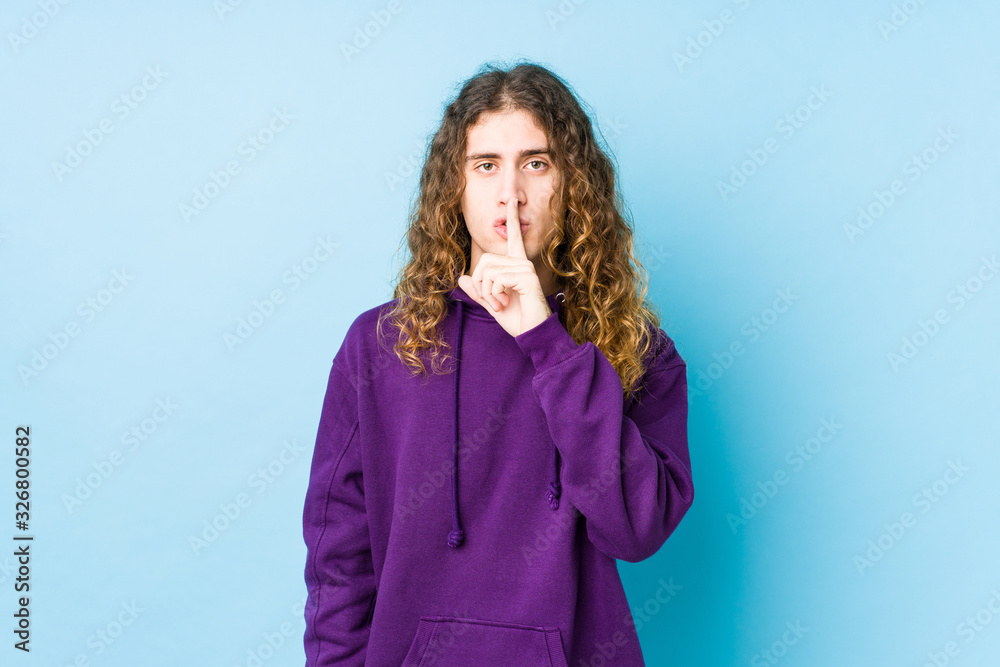 Long hair man posing isolated keeping a secret or asking for silence. Long hair man posing isolated keeping a secret or asking for silence.