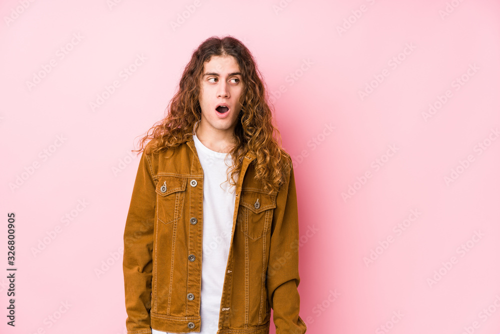 Young long hair man posing isolated being shocked because of something she has seen. Young long hair man posing isolated being shocked because of something she has seen.
