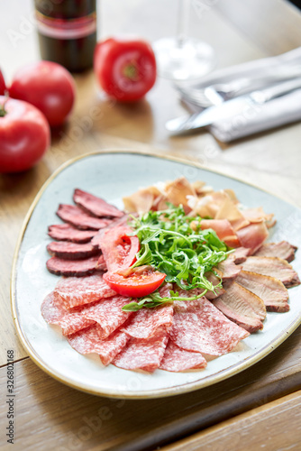 Close-up of Meat on a fork. Meat plate, delicacy and Anantipasto. Salami, roast beef, Parma ham, smoked duck breast. Restaurant menu.