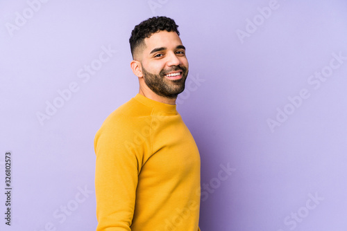 Fotografia Young mixed race arabic man isolated looks aside smiling, cheerful and pleasant