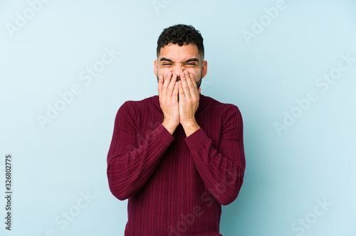 Young mixed race arabic man isolated laughing about something, covering mouth with hands.