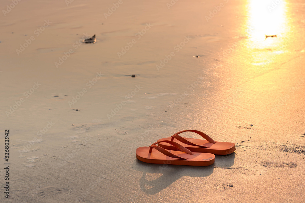 Sandals on a beach. Summer vacation concept, Orange Flip flops on a sandy ocean beach. Stylish flip flops on sand near sea, space for text. Beach accessories. Sandals on a beach. Summer vacation concept, Orange Flip flops on a sandy ocean beach. Stylish flip flops on sand near sea, space for text. Beach accessories.