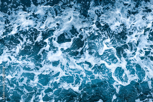 Aerial view of salt ocean waves. Blue water aqua sea background ot texture. Rippled spashing waves.
