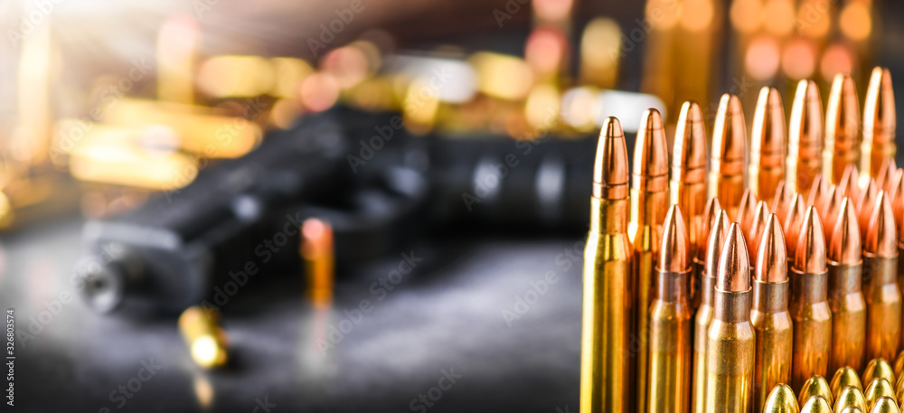 Various kind of bullets or ammonution on dark stone table. Bullet pile in war ammo background. Magazines, rounds and military technology. Wide banner or panorama guns photo..