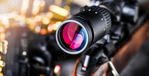 Canvas Print Detail of rifle scope for hunting on wooden ammo background