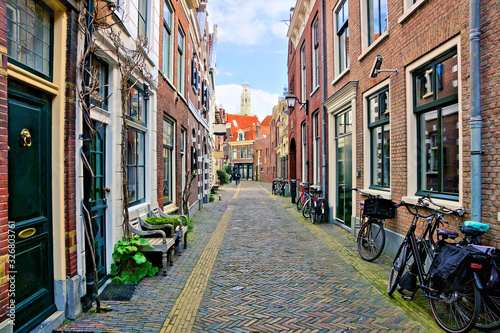 Photography Quaint cobblestone Dutch street lined with bicycles, Haarlem, Netherlands