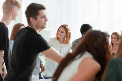 group of diverse young people standing around a round table