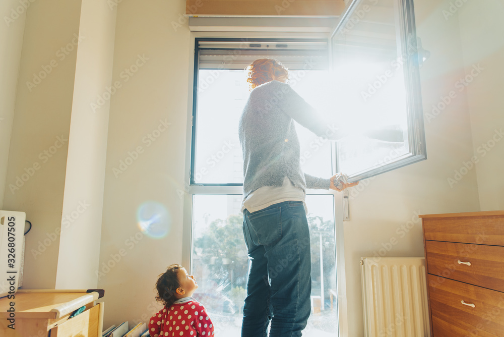 Baby watches his mother while cleaning and tidying the house. Baby watches his mother while cleaning and tidying the house.