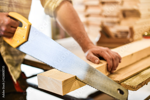 Worker hands use a wood cutter or saw on wooden board. Carpenter work in action. photo