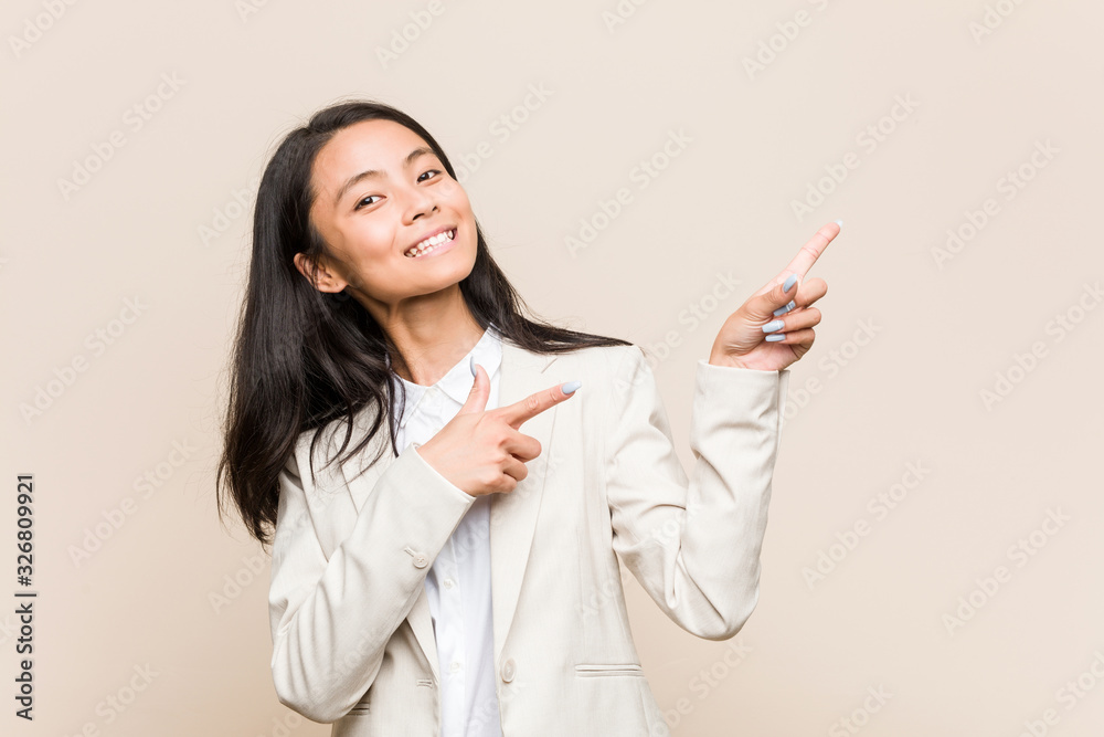 Young business chinese woman pointing with forefingers to a copy space, expressing excitement and desire. Young business chinese woman pointing with forefingers to a copy space, expressing excitement and desire.