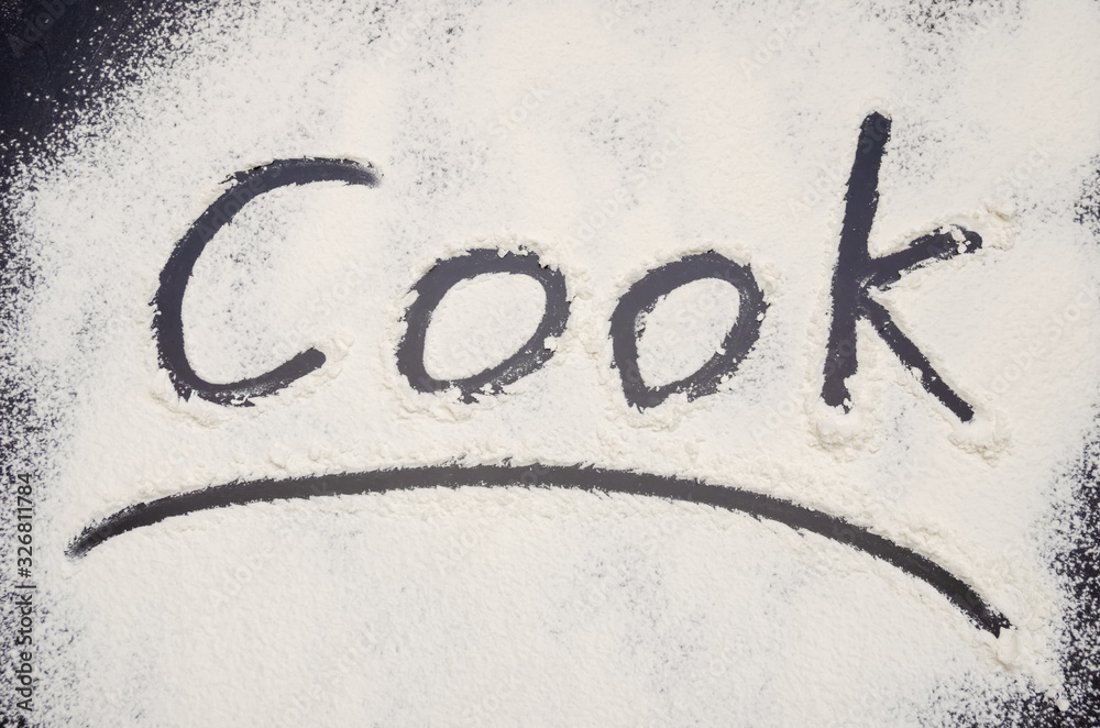 words Cook written on a black background with flour. Inscription. words Cook written on a black background with flour. Inscription.