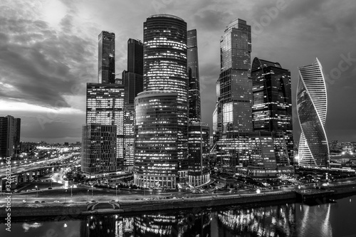 Business district of the city. Night photography of the financial center of Moscow. Skyscrapers shimmering with colorful lights. Reflection in the water of the river.