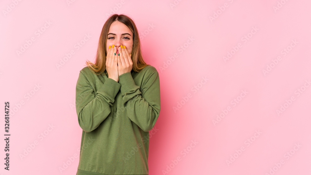 Young caucasian woman isolated on pink background laughing about something, covering mouth with hands. Young caucasian woman isolated on pink background laughing about something, covering mouth with hands.