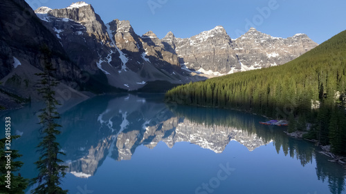 early morning view of reflections on moraine lake in banff np, canada