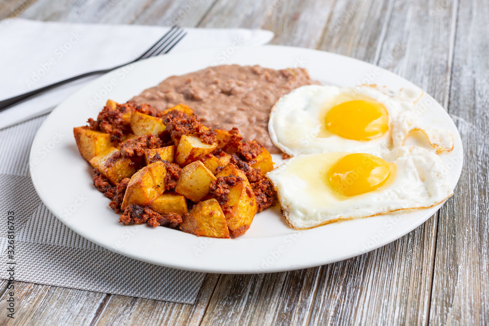 A view of a plate of potatoes and chorizo, in a restaurant or kitchen setting. A view of a plate of potatoes and chorizo, in a restaurant or kitchen setting.