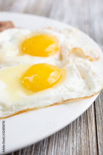 Slika na platnu A closeup view of two sunny side up eggs or fried eggs in a restaurant or kitchen setting