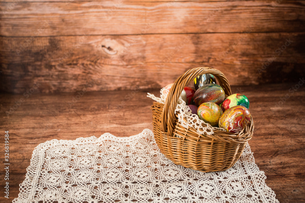 Easter eggs in a basket. Easter decoration. On the wooden background