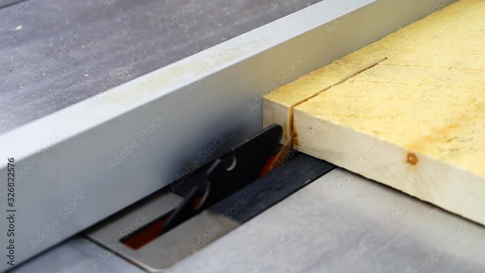 Cutting a piede of wood in an electric saw Cutting a piede of wood in an electric saw