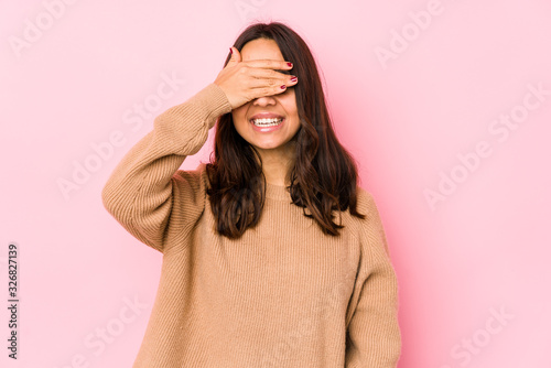 Young mixed race hispanic woman isolated covers eyes with hands, smiles broadly waiting for a surprise. © Asier