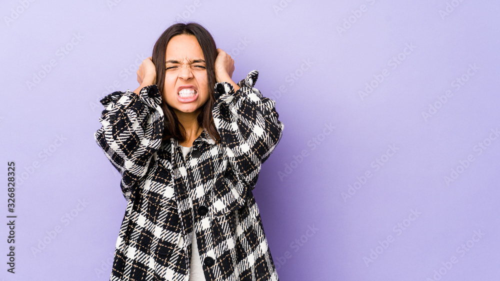 Young mixed race hispanic woman isolated covering ears with hands. Young mixed race hispanic woman isolated covering ears with hands.