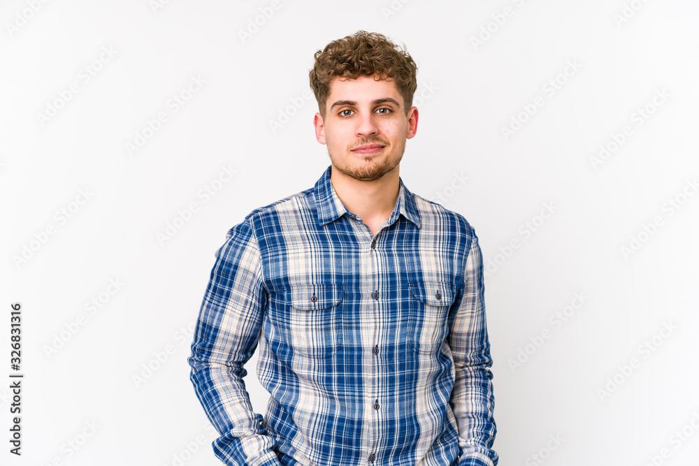 Young blond curly hair caucasian man isolated who feels confident, crossing arms with determination. Young blond curly hair caucasian man isolated who feels confident, crossing arms with determination.