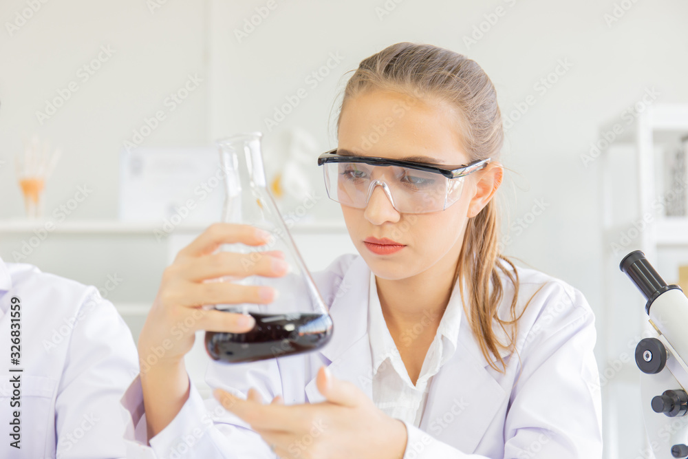 A beautiful female scientist is operating in a science lab with various equipment in the lab. A beautiful female scientist is operating in a science lab with various equipment in the lab.