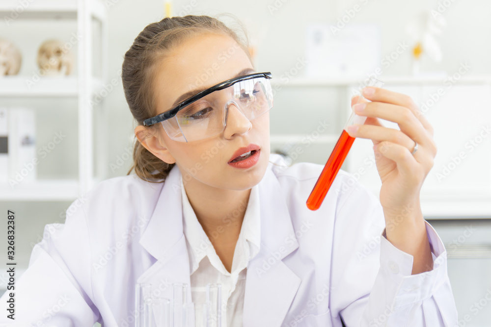 A beautiful female scientist is operating in a science lab with various equipment in the lab. A beautiful female scientist is operating in a science lab with various equipment in the lab.