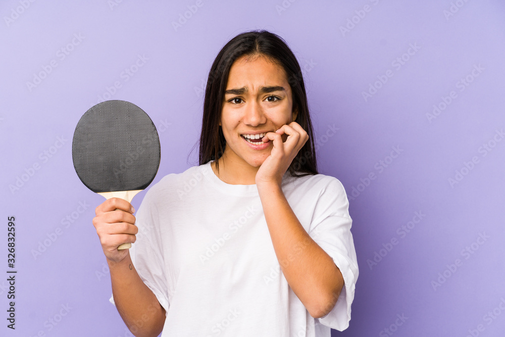 Young indian woman playing ping pong isolated biting fingernails, nervous and very anxious. Young indian woman playing ping pong isolated biting fingernails, nervous and very anxious.