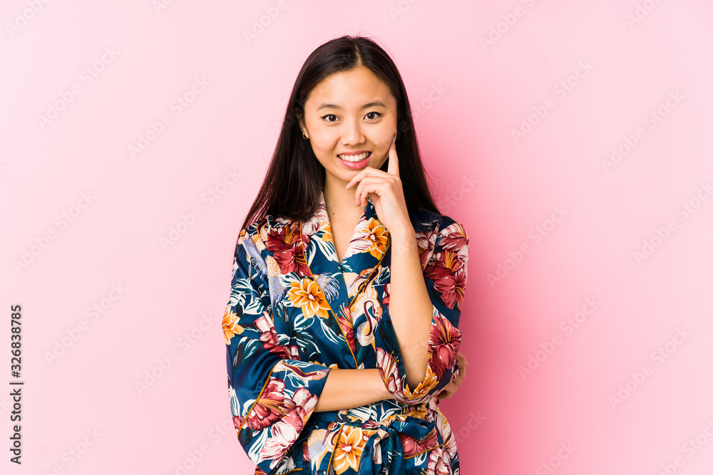 Young chinese woman wearing a kimono pajama isolated smiling happy and confident, touching chin with hand. Young chinese woman wearing a kimono pajama isolated smiling happy and confident, touching chin with hand.