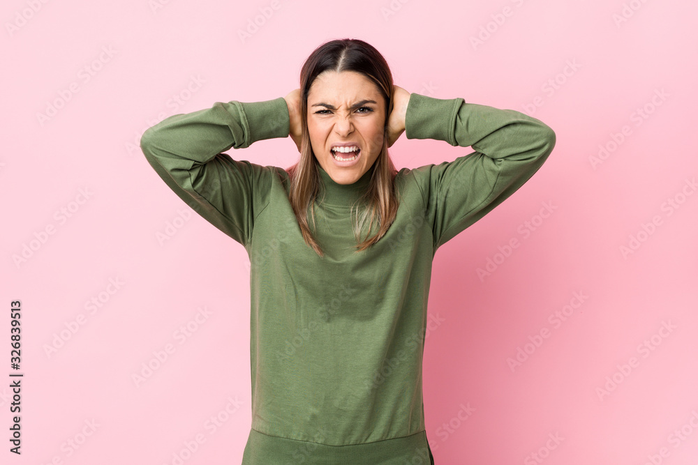 Young caucasian woman isolated covering ears with hands trying not to hear too loud sound. Young caucasian woman isolated covering ears with hands trying not to hear too loud sound.