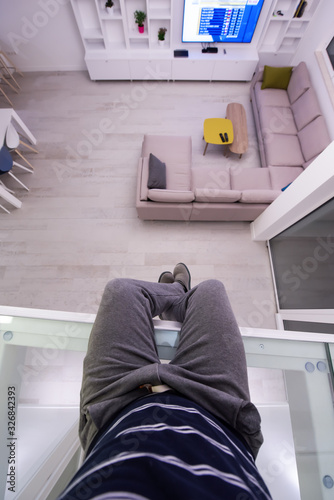 man sitting upstairs on glass floor