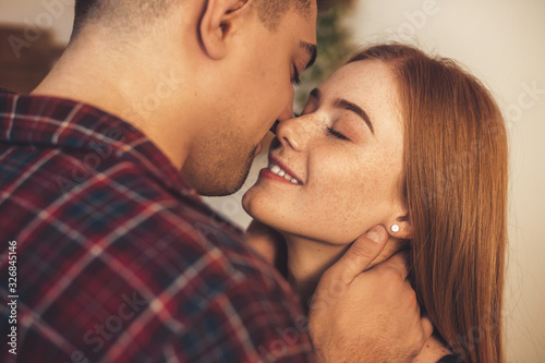 Lovely caucasian ginger girl with freckles is having special moments with her lover kissing and embracing each other