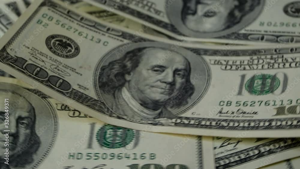 A lot of banknotes. Hundred american dollars banknotes, obverse side up, rotation on circle. Financial background. Selective focus.