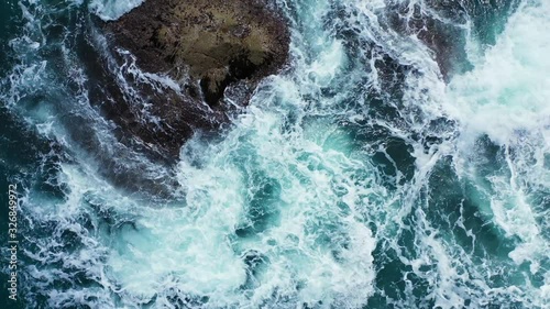 rough sea waves crashing on the rock in the emerald sea.Aerial vertical background