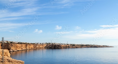 Egypt  Sharm El Sheikh  Seaside coast  palm trees  houses  buildings against the blue sky.