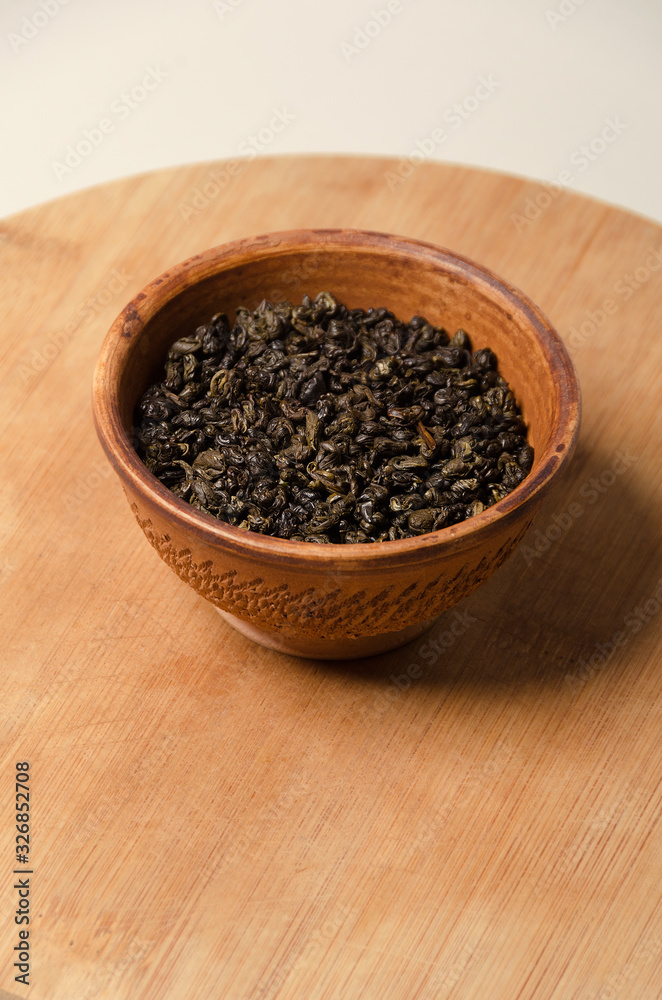 Green tea. Natural leaf of Chinese tea. Ingredient in a clay cup. Antioxidant and healthy life. Green tea. Natural leaf of Chinese tea. Ingredient in a clay cup. Antioxidant and healthy life.