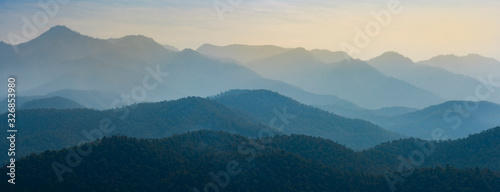Amazing wild nature view of layer of mountain forest landscape with cloudy sky. Natural green scenery of cloud and mountain slopes background. Maehongson,Thailand. Panorama view. © Thanumporn