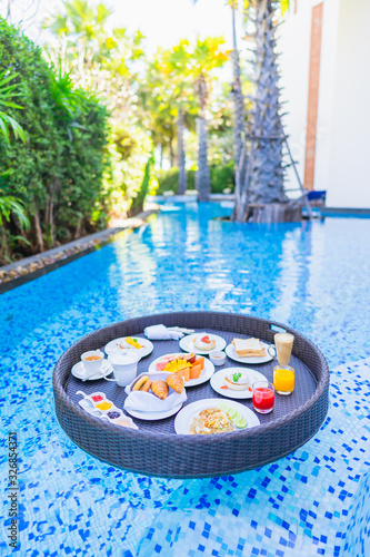 Floating breakfast set in tray with fried egg omelette sausage ham bread fruit milk juice coffee © siraphol