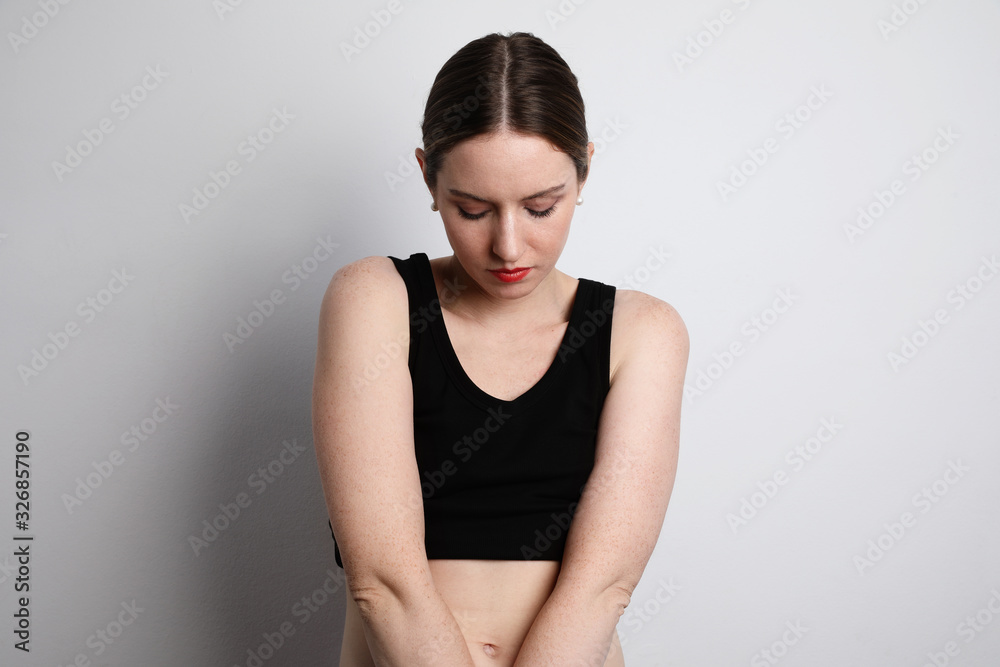 A woman wearing a black top and posing on the white background. A woman wearing a black top and posing on the white background.