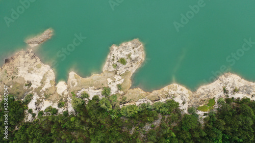 Aerial top down view of Lake Grahovo in mountains. Beautiful landscape of Montenegro nature. Emerald water of Grahovsko Jezero. Sand and stone coast. Forest with green trees. Niksic, Montenegro. photo