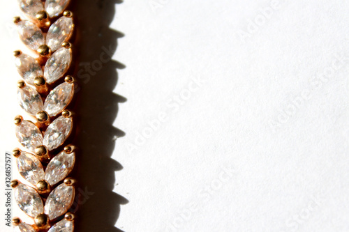 gold decoration strip with stones on a white background.Architectural decorative element . Abstract background. White fabric background, white fabric texture. Abstract wallpaper