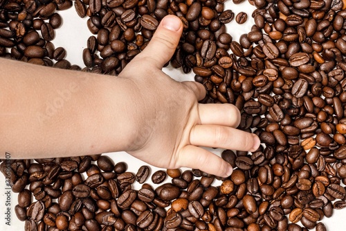 child s hand draws a smiley face with a smile from coffee beans. hollow nai white background