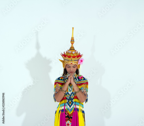 woman wearing Thai Tradition southern costume and put headdress on her head,standing on white background