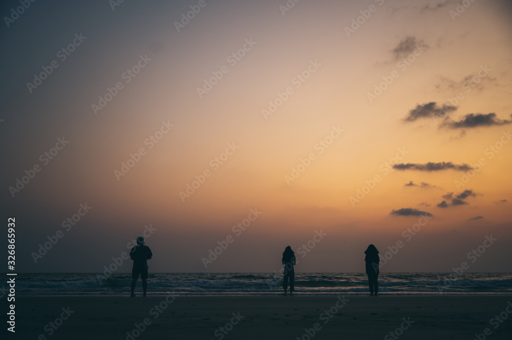 Silhouette of a group of friends Seaside during sunset