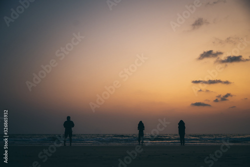 Silhouette of a group of friends Seaside during sunset