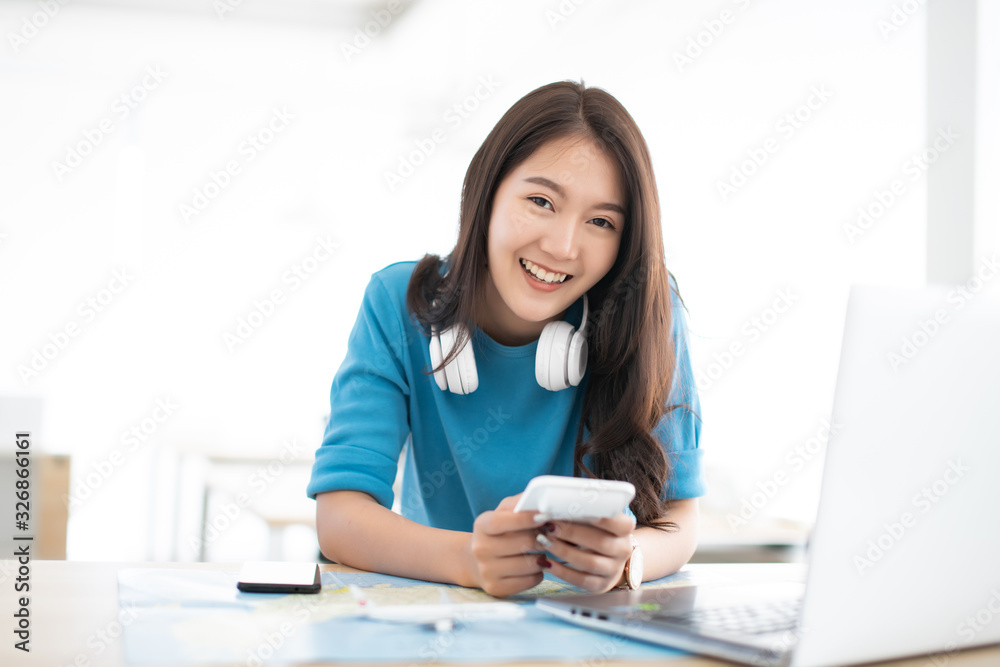 Asian woman happy with searching information booking budget ticket and compare cost for travel vacation plan Asian woman happy with searching information booking budget ticket and compare cost for travel vacation plan